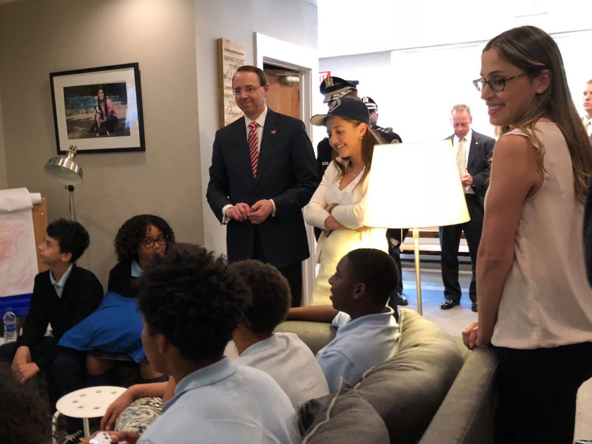 A group of people standing around in a room.