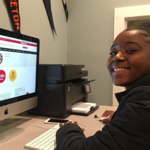 A young boy sitting at his computer desk.