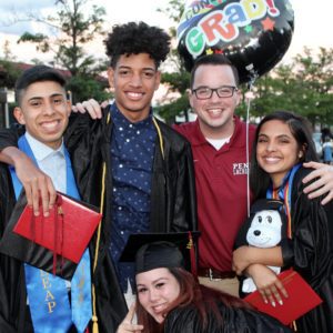 A group of people in graduation attire posing for the camera.