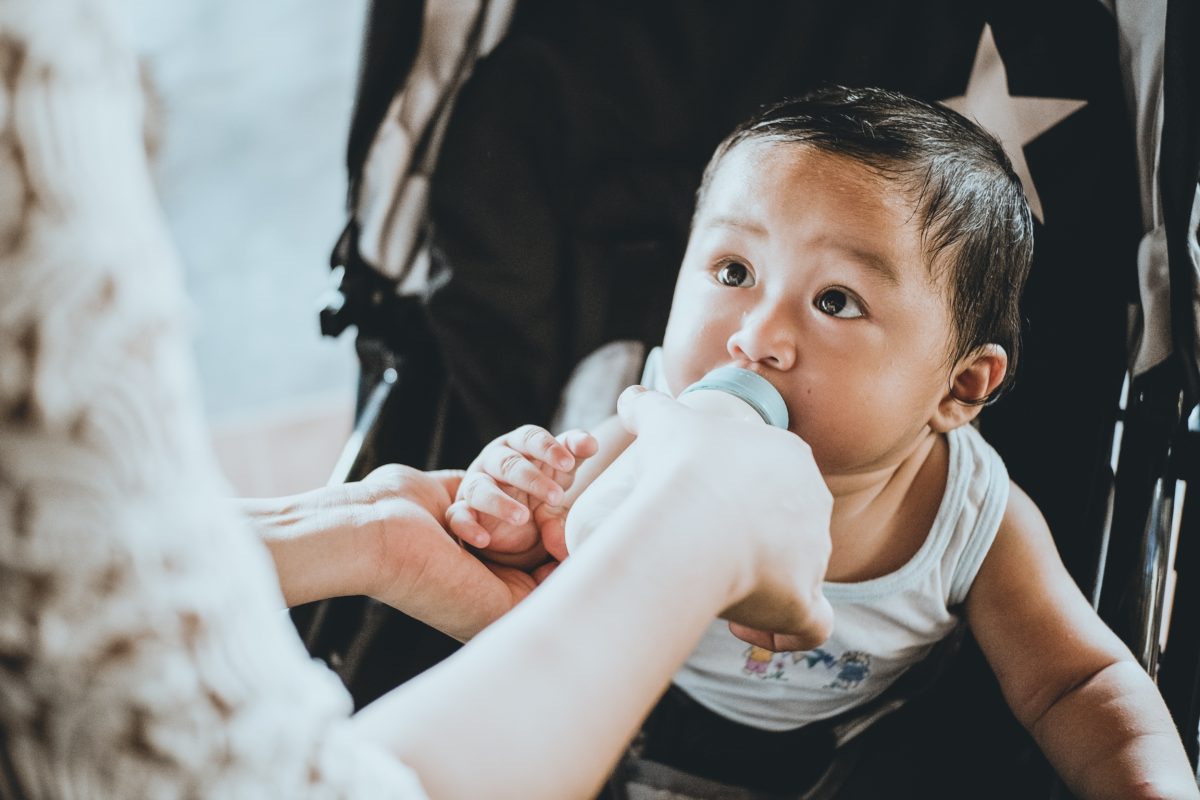 A baby is being fed by someone else.