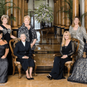 A group of women in formal wear posing for a picture.