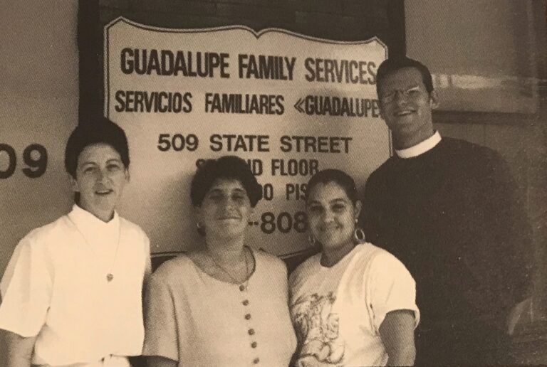 A family standing in front of a sign.