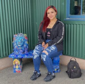 A woman sitting on top of a bench.