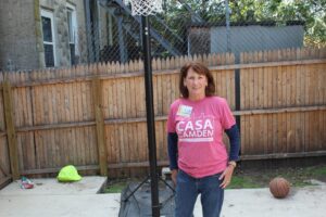 A woman standing next to a basketball hoop.